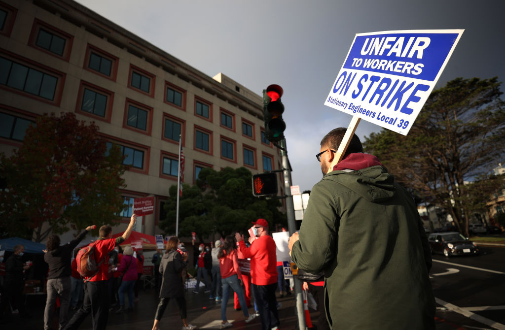 A union worker holds a strike sign as he pickets with nurses outside of the Kaiser Permanente San Francisco Medical Center on November 10, 2021 in San Francisco, California.