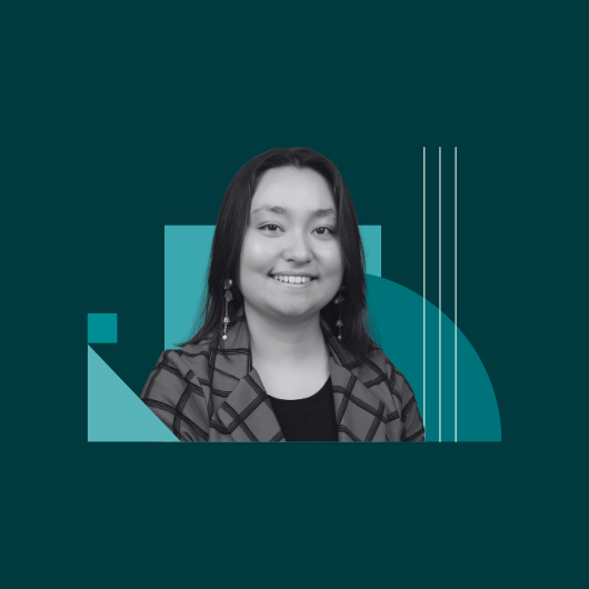 A person with long dark hair smiles, wearing a checkered jacket. The grayscale portrait is set against a teal background with geometric shapes and lines.