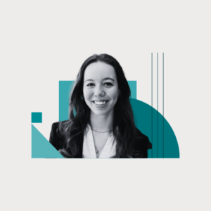 A woman with long hair, wearing a blazer and white shirt, smiles at the camera. The background features abstract teal geometric shapes on a white backdrop.