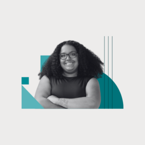 A smiling person with curly hair and glasses stands with arms crossed. They wear a sleeveless top. Blue geometric shapes decorate the background.