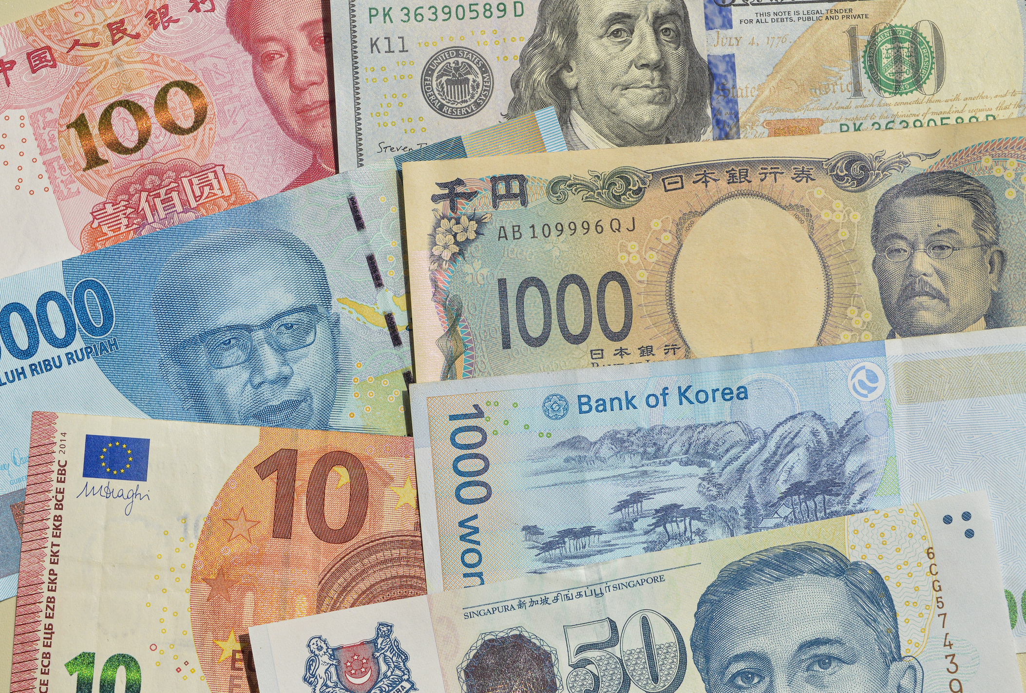 Various international banknotes, including Chinese yuan, US dollar, Japanese yen, Indonesian rupiah, South Korean won, Singapore dollar, and euro, are arranged in an overlapping pattern.