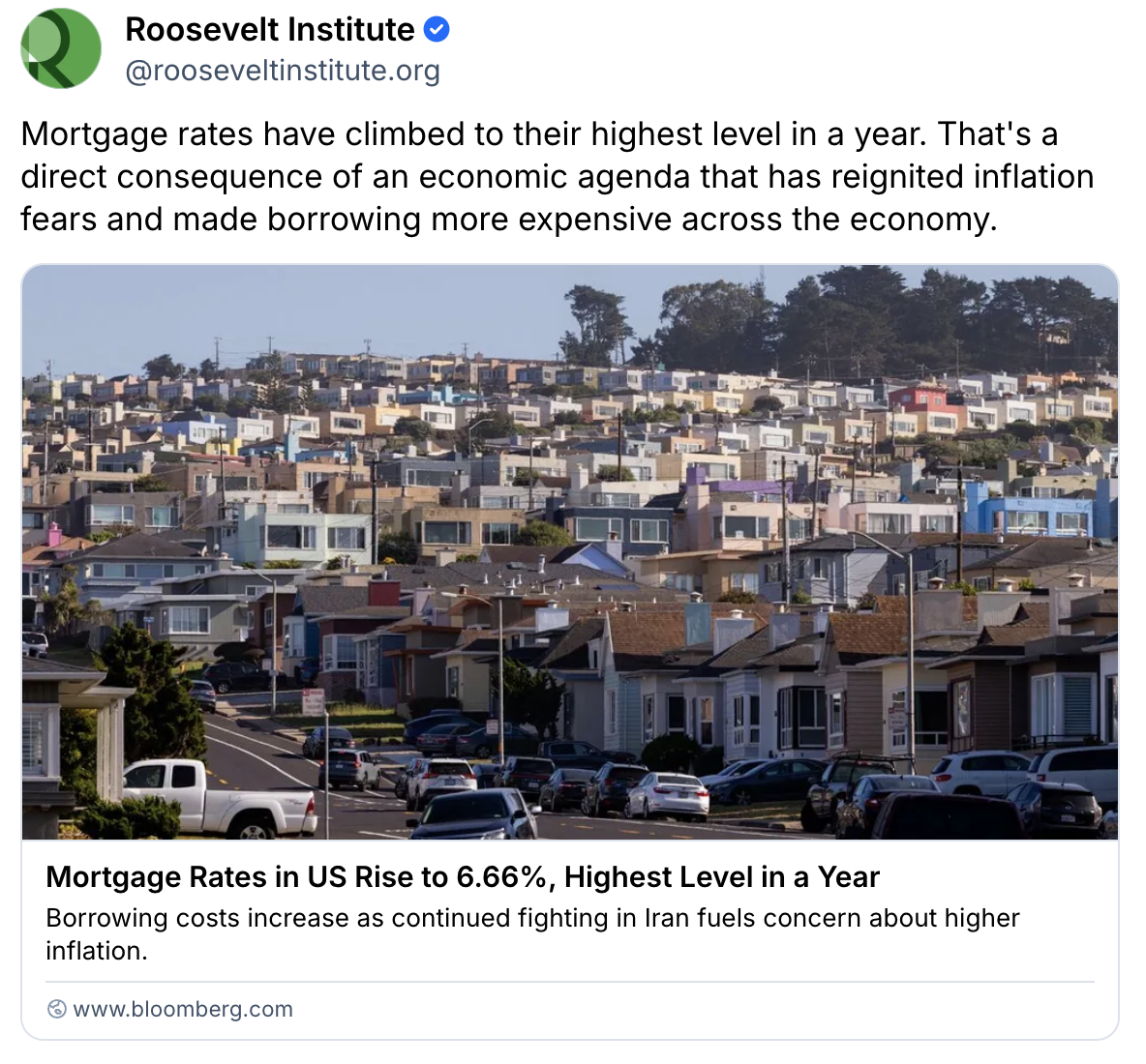 A suburban neighborhood with rows of similar houses under a clear sky. Cars are parked along the street. The image accompanies a news headline about rising US mortgage rates.