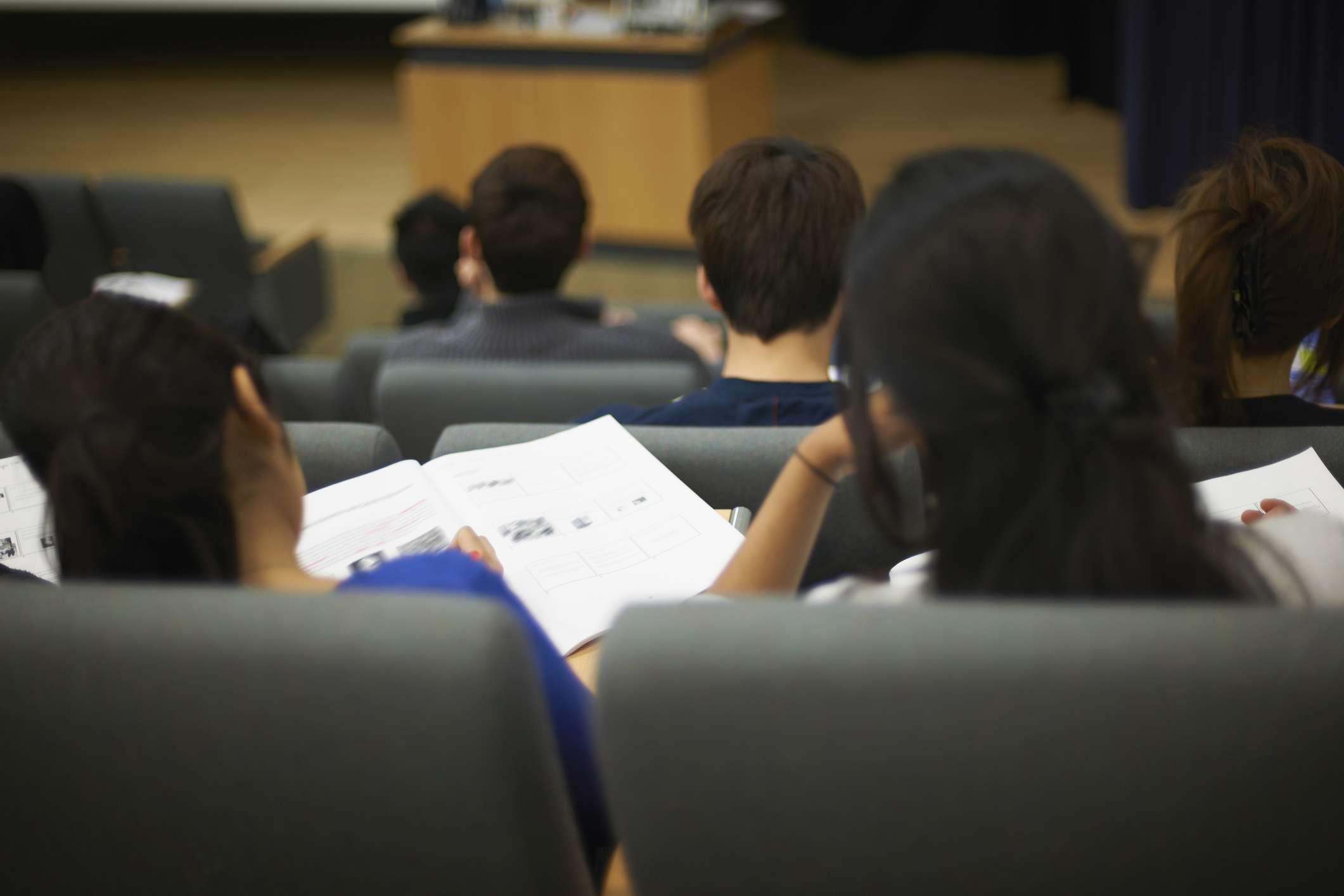 Students sit in a lecture hall viewing documents during a class.